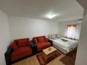 uma sala de estar com um sofá e uma cama em Apartmani Ušće em Trstenik