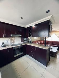una cocina con armarios marrones y un sofá. en Kingsley Executive Villa, en Brakpan