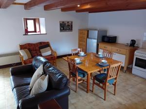 ein Wohnzimmer mit einem Tisch und einem Ledersofa in der Unterkunft Caurelgranges in Caurel