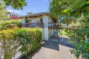 una casa con balcón y árboles frente a ella en Sunny Cosy stay in Auckland, en Auckland