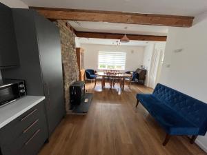 a living room with a blue couch and a table at Greengates of Shouldham in Shouldham