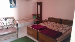 a bedroom with a bed and a chair in it at Giriraj Darshan in Govardhan