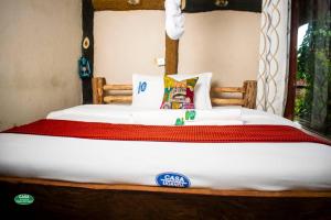 Bett in einem Zimmer mit weißer Tagesdecke in der Unterkunft Sipi Falls Cottages in Sipi