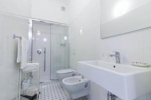 Baño blanco con lavabo y aseo en Al Ciglio Holiday House Amalfi Coast, en Scala