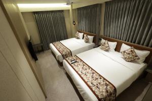 two beds in a hotel room next to each other at Hotel Sapphire 26 in Surat
