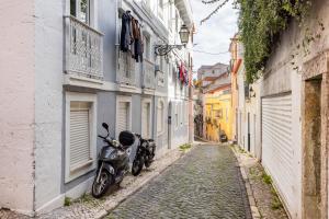 a motorcycle parked on a cobblestone street in an alley at Avenida da Liberdade Area, Bright and Newly Renovated 2 Bedroom Apartment, Lisbon Historical Center in Lisbon