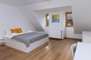 a white bedroom with a bed and two windows at Primus apartments in Ljubljana