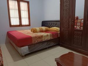 um quarto com uma cama, uma mesa e uma janela em House 08 em Pekalongan