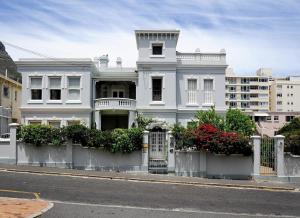 uma casa branca com um portão numa rua em Barry Hall Apartments em Cidade do Cabo