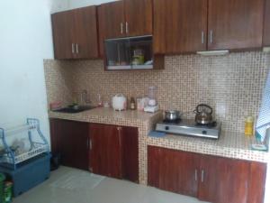 una cucina con armadi in legno e una parete piastrellata di House 08 a Pekalongan
