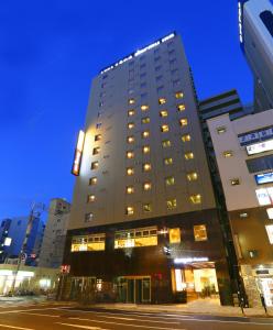 大阪的住宿－多美迎 PREMIUM 難波飯店，夜幕降临的城市街道上一座高楼