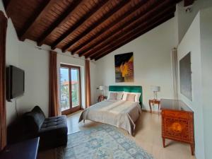 sypialnia z łóżkiem, kanapą i telewizorem w obiekcie Suite with Lake Como view w mieście Colico