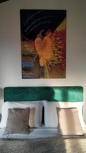 a bedroom with a bed with a painting above it at Suite with Lake Como view in Colico