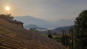 een dak van een huis met bergen op de achtergrond bij Suite with Lake Como view in Colico