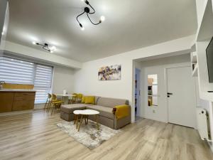 a living room with a couch and a table at Yellow Apartment in Floreşti