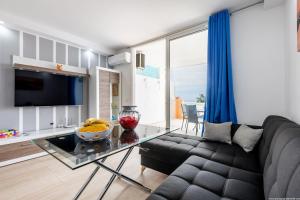 a living room with a couch and a glass table at Ocean View Apartment with large terrace and Netflix smart TV Costa Adeje in Adeje