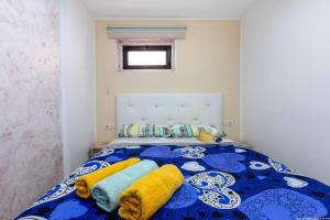 a bedroom with a blue and white bed with yellow blankets at Ocean View Apartment with large terrace and Netflix smart TV Costa Adeje in Adeje
