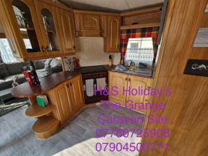 an overhead view of a kitchen with wooden cabinets at H&S Holidays in Addlethorpe