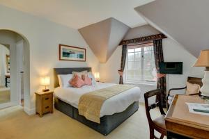 a bedroom with a bed and a desk and a window at The Crown Hotel in Exford
