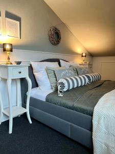 een slaapkamer met een bed met een nachtkastje en een tafel bij Cottage & Garden & Sauna am See in Wettringen