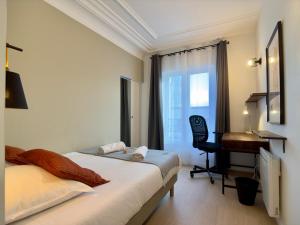 a bedroom with a bed and a desk and a keyboard at Rouen Hypercentre - Le relais des Amis in Rouen