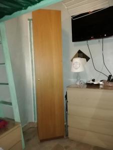 um quarto com um armário de madeira e uma televisão na parede em Room in House - 2 floors 2 bedrooms near Central Station em Antuérpia