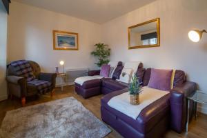 a living room with purple furniture and a couch and chair at 5 wheelhouse apartments in Lochinver