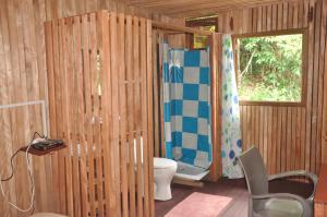 bagno in legno con servizi igienici e finestra. di Kribi-Lodge a Kribi Altre 37 foto