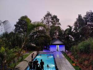 a group of people standing around a swimming pool at Verdant Hillock in Wayanad