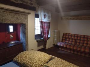 a bedroom with a bed and a couch in it at Rifugio Monte Zeus in Baceno