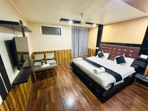 Habitación de hotel con cama y TV en Hotel Luxury Inn, en Srinagar