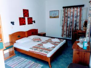 a bedroom with a bed with a wooden frame and a table at Blue Horizon Studios in Lefkos Karpathou