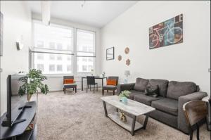 a living room with a couch and a table at CozySuites - 2BR with Direct Skybridge Access #6 in Indianapolis