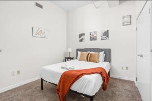 sypialnia z łóżkiem z pomarańczowym kocem w obiekcie CozySuites - 2BR with Direct Skybridge Access #6 w mieście Indianapolis