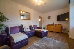 a living room with a couch and a tv at 5 wheelhouse apartments in Lochinver