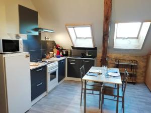 a kitchen with a table and a white refrigerator at Le Pigeonnier in Martel