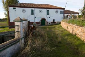 een oud wit huis met een hek ervoor bij El Molino de Valeriano - Casa Rural in Sancti Spíritus