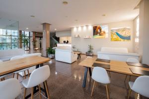 una sala de espera con mesas y sillas blancas en Hotel Auditorio Santiago & Spa, en Lugo