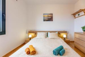 1 dormitorio con 1 cama con 2 toallas en Sunrise Surf House, Big Garden, Hot Tub, Parking, super-fast free Wi-Fi, en Corralejo