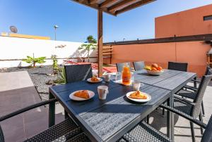 una mesa con dos platos de comida en un patio en Sunrise Surf House, Big Garden, Hot Tub, Parking, super-fast free Wi-Fi, en Corralejo