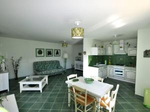 kuchnia i salon ze stołem i kanapą w obiekcie Résidence U MELU Grand T2 VERT à l'étage w mieście Tiuccia
