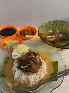 une assiette de nourriture avec du riz, de la viande et de la sauce dans l'établissement Kana Citra Guesthouse, à Surabaya