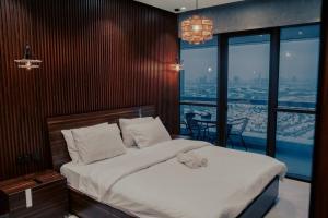 a bedroom with a bed with a view of a city at Luxury 3 Bedroom Sub Penthouse With Rooftop Pool in Dubai