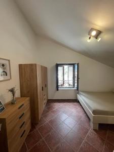 um quarto no sótão com uma cama e uma janela em Apartment Atina em Kotor