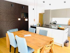 uma cozinha e sala de jantar com uma mesa de madeira e cadeiras em Luxus-Mountain-Suite Belvita mit Sauna em Flims
