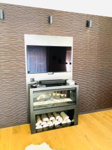 uma prateleira num quarto com uma televisão de ecrã plano em Luxus-Mountain-Suite Belvita mit Sauna em Flims