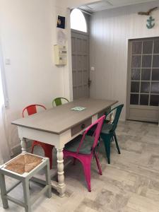 ein Tisch mit vier Stühlen in einem Zimmer in der Unterkunft Charmante Maison, terrasse vue mer in Les Sables-dʼOlonne