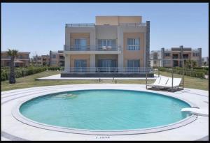une grande piscine en face d'un bâtiment dans l'établissement Tolip Resort Sunrays New- Alamein, à El Alamein