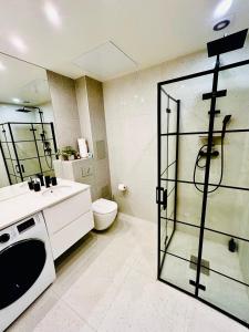 a bathroom with a toilet and a glass shower backdoor at Apartment Targowa L9 in Lublin