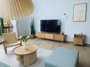 uma sala de estar com uma televisão e uma mesa em 【森林城市高尔夫别墅民宿】独门独院 em Gelang Patah